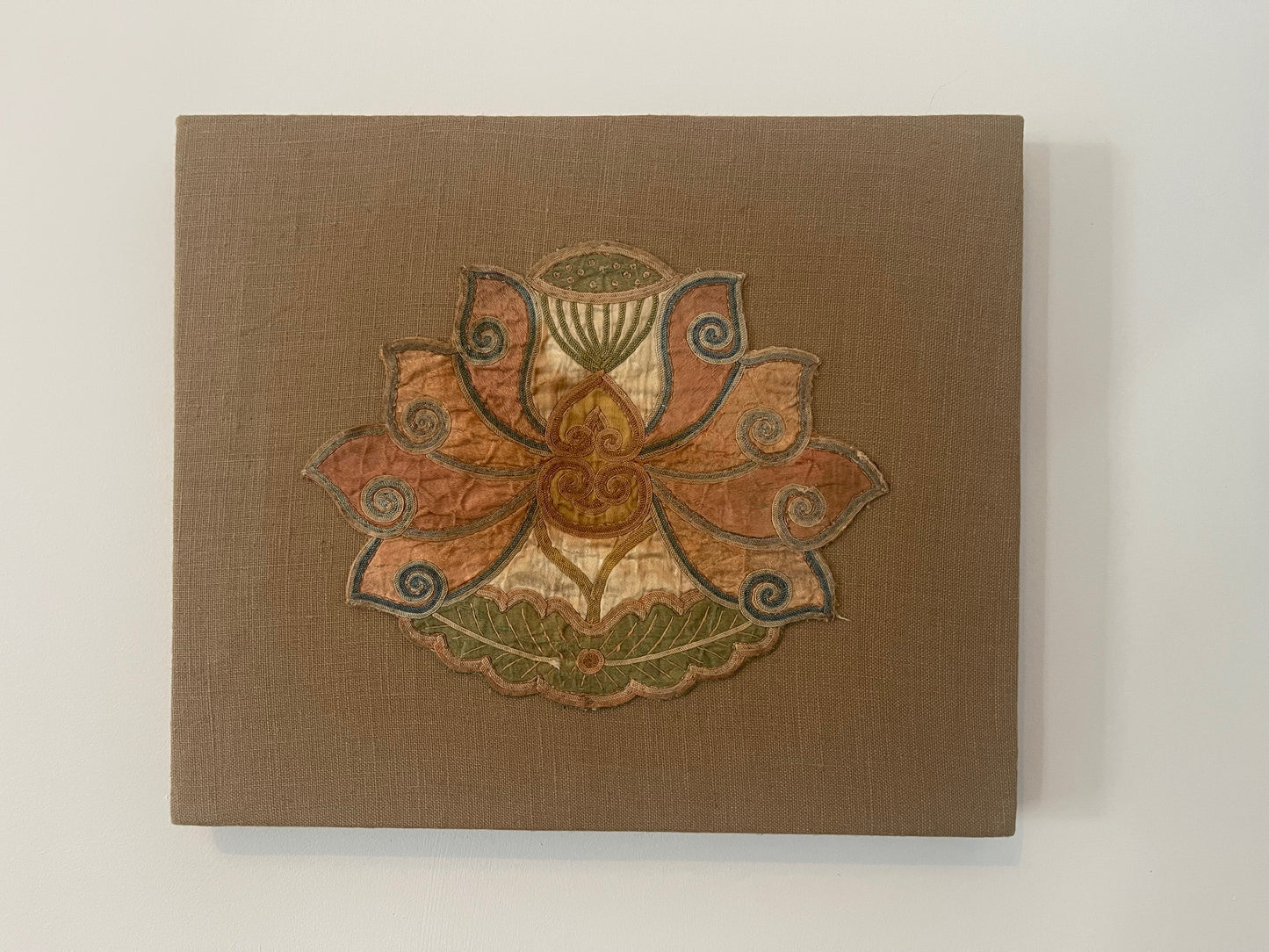 An antique lotus applique art mounted on a fabric frame