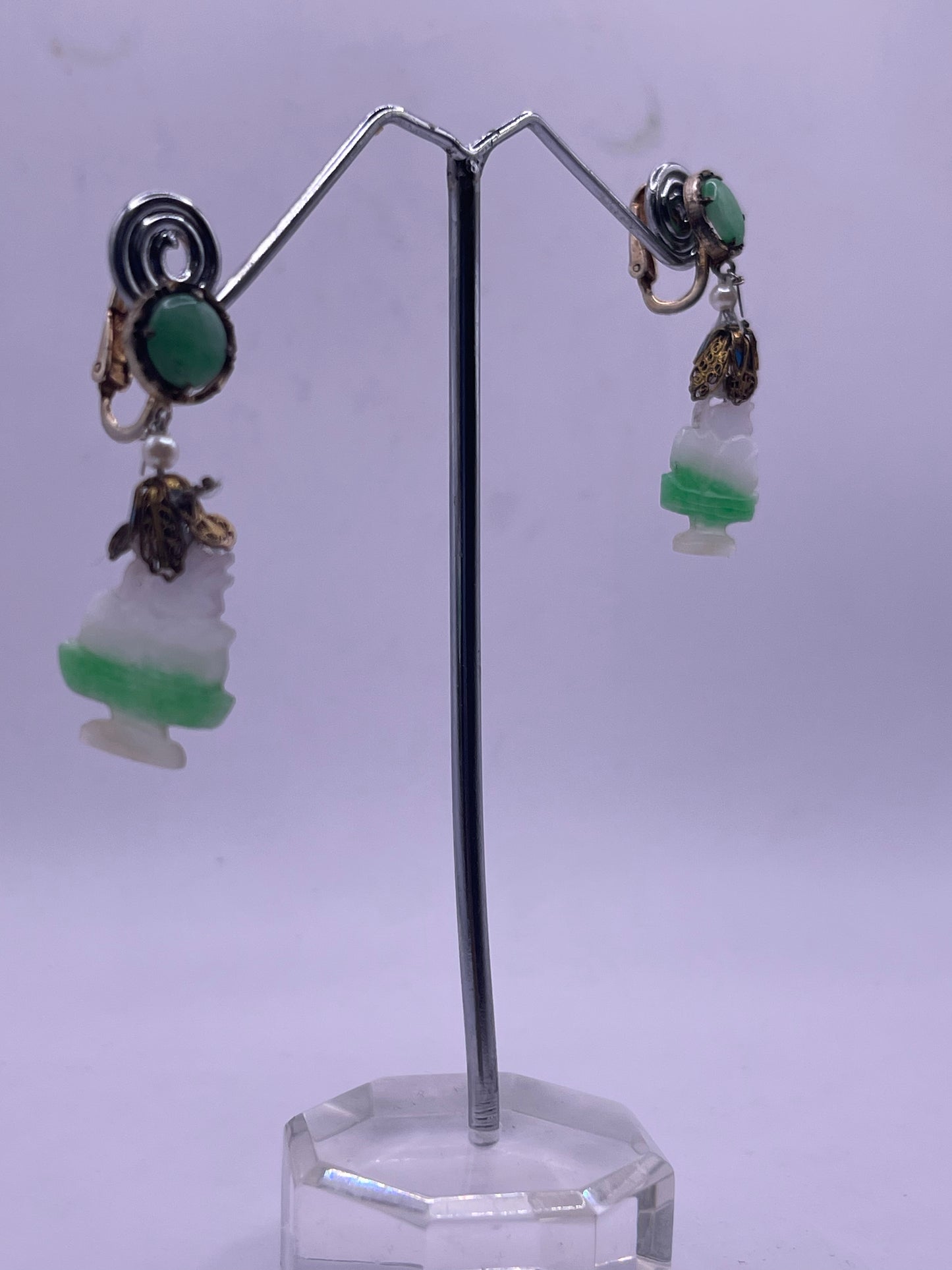 A pair of carved jade earrings in a gilded silver setting