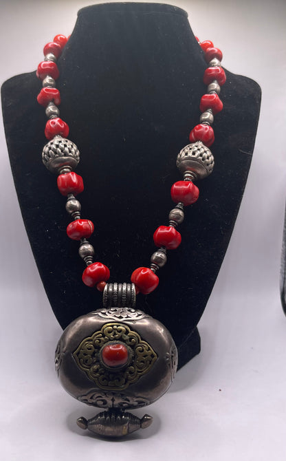 Antique Tibetan coral ghau pendant with a coral and silver necklace