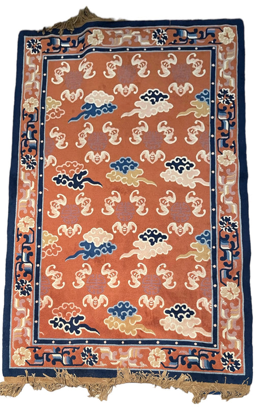 A mid 20th C. Peking rug with clouds and bats motifs