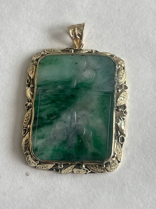 A vintage pendant with a jade plaque in a 10 kt setting