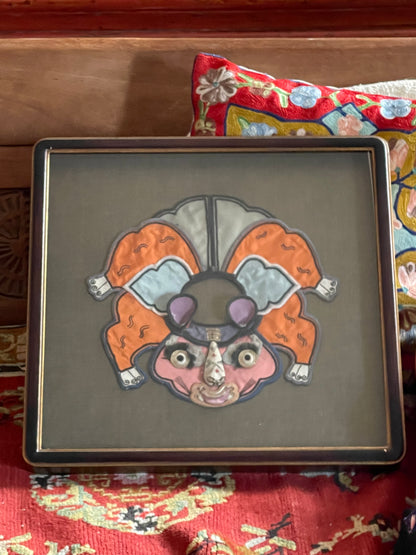 An antique childrens collar with an animal design in a box frame