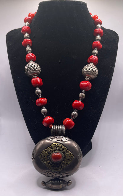 Antique Tibetan coral ghau pendant with a coral and silver necklace