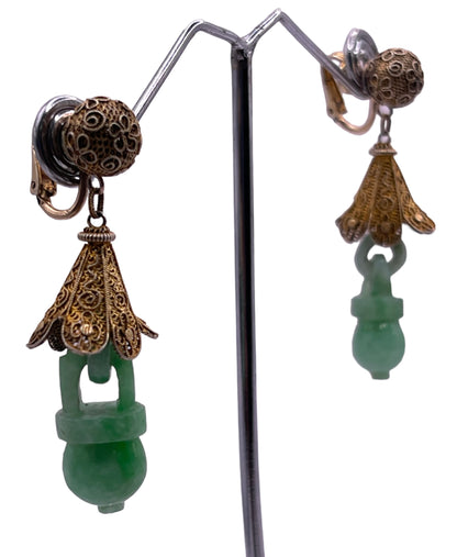 A pair of carved jade earrings in a gilded silver setting