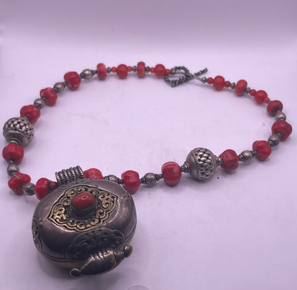 Antique Tibetan coral ghau pendant with a coral and silver necklace