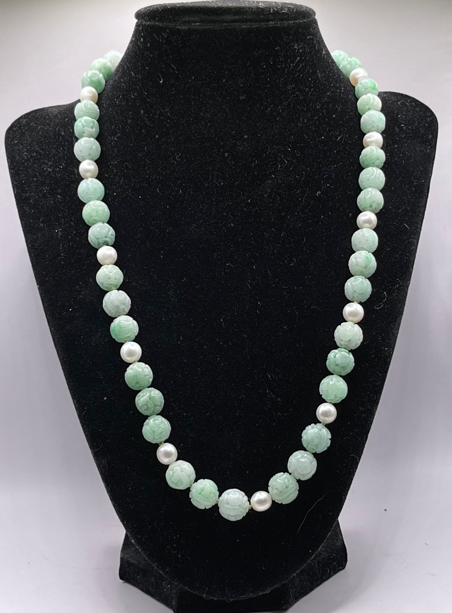 A necklace with vintage carved jade shou beads and pearls