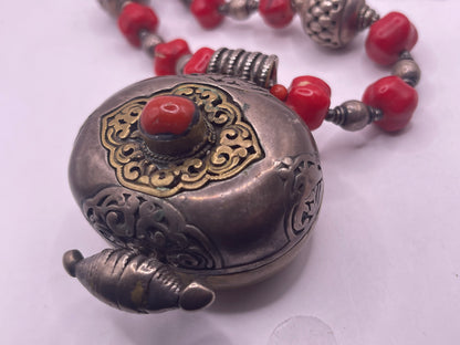 Antique Tibetan coral ghau pendant with a coral and silver necklace