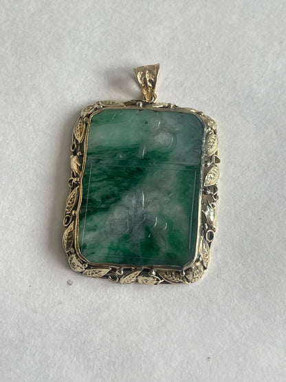A vintage pendant with a jade plaque in a 10 kt setting