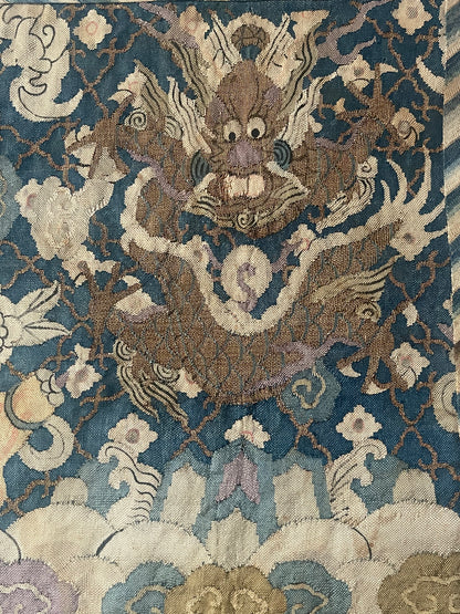 An antique framed Chinese silk kesi of a pair of dragons
