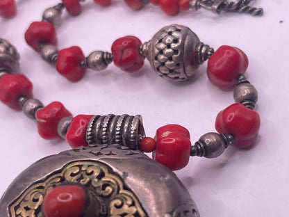 Antique Tibetan coral ghau pendant with a coral and silver necklace