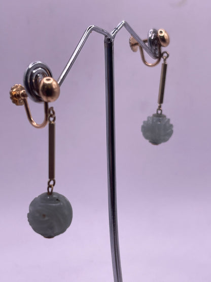 A pair of carved jade shou beads in a 14kt setting
