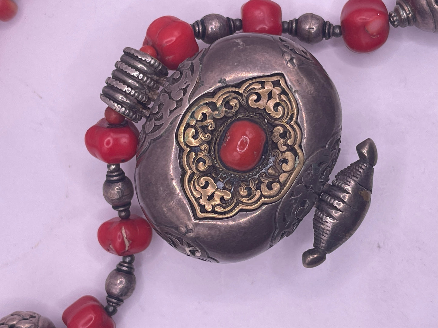 Antique Tibetan coral ghau pendant with a coral and silver necklace